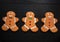 Three Gingerbread Men cookies on black