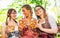 Three girl friends, having fun in beer garden holding Traditional Bavaria pretzels, Germany