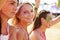 Three girl friends at a music festival, one turned to camera