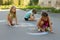 Three girl kids absorbedly drawing chalks on the pavement