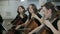 Three girl play on violoncello in orchestra