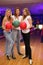 Three girls with balls stand in bowling club