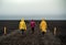 Three girls in bright clothes go along the Icelandic road