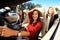 Three girls driving in a convertible car and having fun.