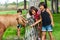 Three girls feeding pony on farm.