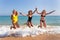 Three girls jumping on beach near sea