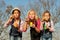 Three girls kids sisters blowing bubbles with soap in a farm fie