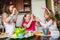 Three girls with painted Easter eggs in their hands are laughing and fooling around at home in the kitchen