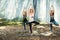 Three girls perform body balance exercises in nature