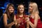 Three girls raised their glasses in a nightclub