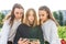 Three girls schoolgirls teenagers 13-15 years old, fall day summer city watch videos smartphone, online application