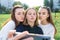 Three girls schoolgirls teenagers summer city. Photography on phone, selfie photo, online app smartphone, social