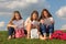 Three girls sit on grass and read something