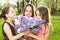 Three girls smelling bouquet Lilac flowers