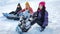 Three girls snowboarders sitting on the snow