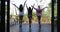 Three Girls Stretching On Terrace In Morning Back Rear View, Looking At Tropical Garden