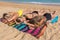 Three girls sunbathe together on beach at sea