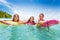 Three girls swim in the sea on surfboards