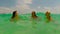 Three girls swimming in sea action camera pov of young woman talking in blue water on beautiful beach