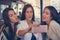 Three girls take a funny face selfie.