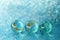 Three glass balls on shiny blue table with shiny blurred background in bubbles