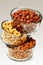 Three glass bowls filled with cashews, salted roasted almonds an