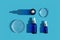 Three glass dropper bottles with pipettes and petri dishes on blue background.