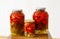 Three glass jars with marinated tomatoes homemade
