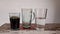 three glasses containing coffee and mineral water
