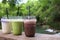 Three glasses of drink - iced cocoa, green tea and frappe coconut juice placing on the wooden table