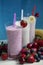 Three glasses of fresh fruit smoothie milkshake with berries and bananas