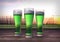 Three glasses of green beer with hop-garden background - 3D render