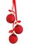 Three glossy red glass glitter Christmas baubles hanging on a red satin ribbon with a bow, isolated