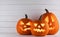 Three glowing Halloween pumpkins