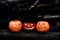 Three glowing Jack O lantern pumpkins in the autumn forest at dusk. Halloween holiday background.