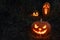 Three Glowing spooky Halloween pumpkin on the ground at night.