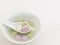 Three glutinous rice balls of different flavors and colors scooped up from a white bowl on a white spoon. copy space.
