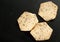 Three golden organic grain crackers on black table