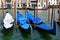 Three gondolas docked in a row in Venice, Italy