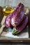 Three graffiti eggplants, pink salt, and olive oil