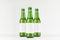 Three green longneck beer bottles 330ml with blank white label on white wooden board, mock up.