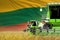 three green modern combine harvesters with Lithuania flag on wheat field - close view, farming concept - industrial 3D