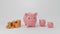 Three growing pink piggy banks and golden coins stacks isolated on white background