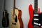 Three guitars hang on a gray wall