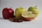 Three and a half apples yellow red green lie on a white background next to cinnamon sticks with a place to insert text