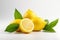 Three halved lemons arranged alongside a selection of green foliage on a flat surface