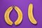 Three halves of a banana on a purple background