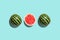 Three halves of watermelon in a row isolated on blue background