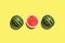 Three halves of watermelon in a row isolated on yellow background