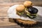 Three hamburgers on wooden background.